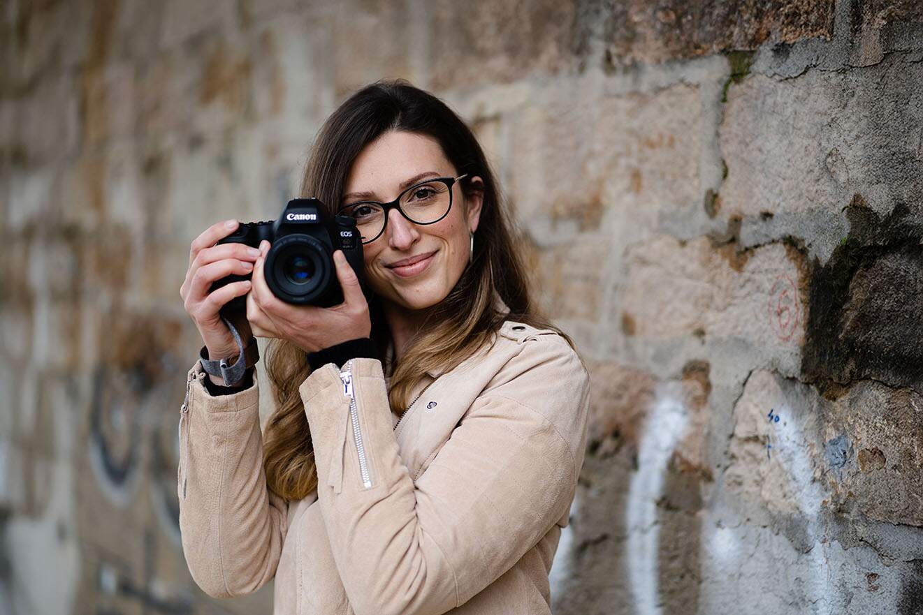 Photographe canine guidant un chien et ses humains pendant une séance photo en extérieur, dans une ambiance douce et respectueuse.